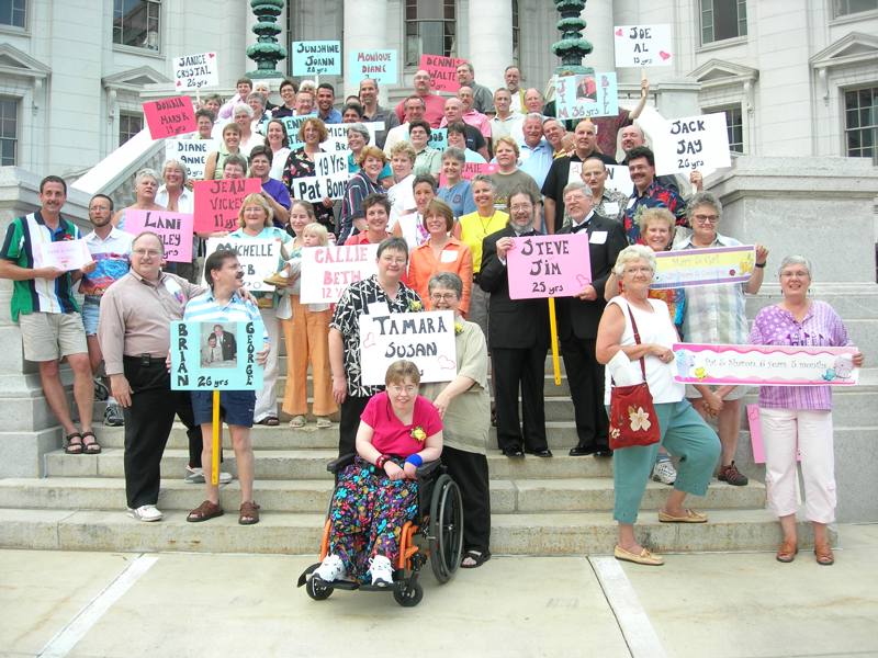 Couples holding signs on the steps of the State Capitol building